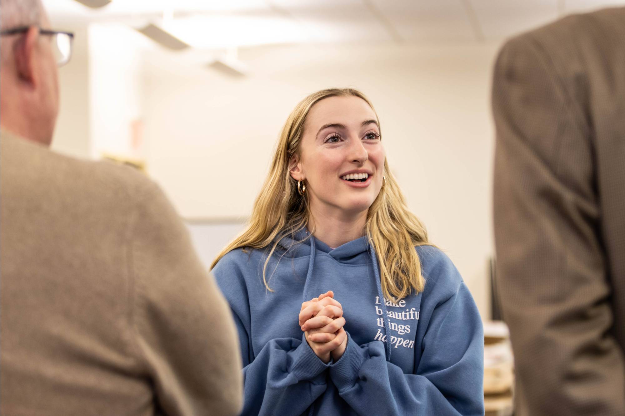 A girl speaking to two people at CreateAThon